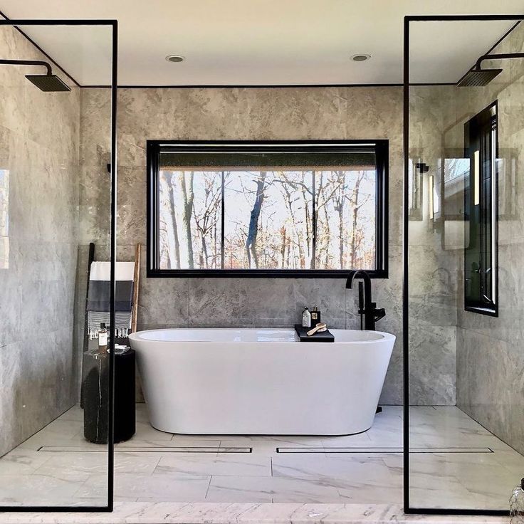 a bathroom with a large tub in the middle of it and mirrors on the wall