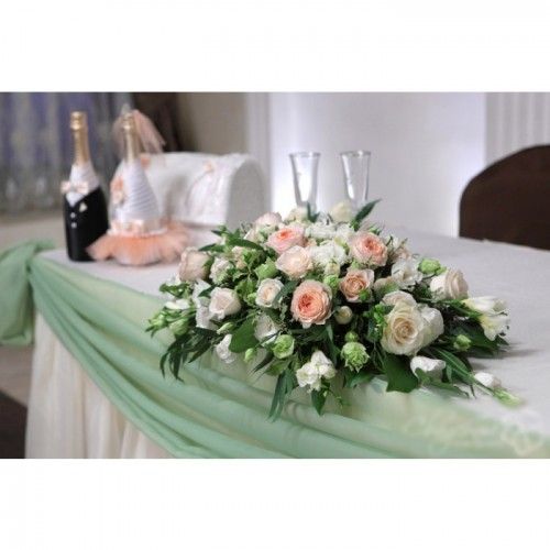 a bouquet of flowers on a table with champagne bottles and napkins in the background