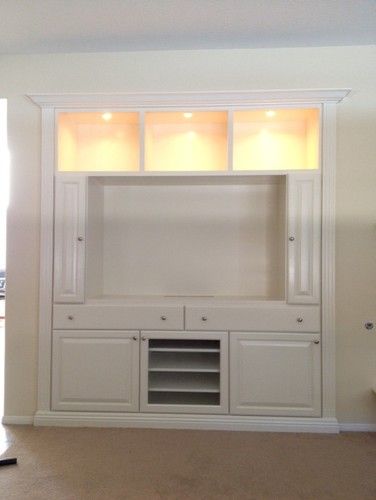 an empty living room with built in cabinets