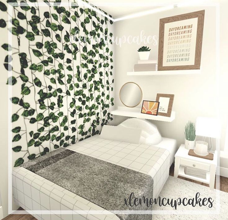 a bed room with a neatly made bed next to a wall covered in green leaves