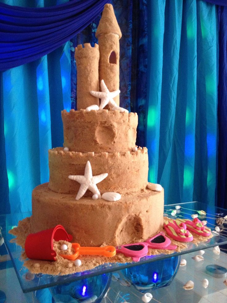 a three tiered cake with sandcastles and starfish on it