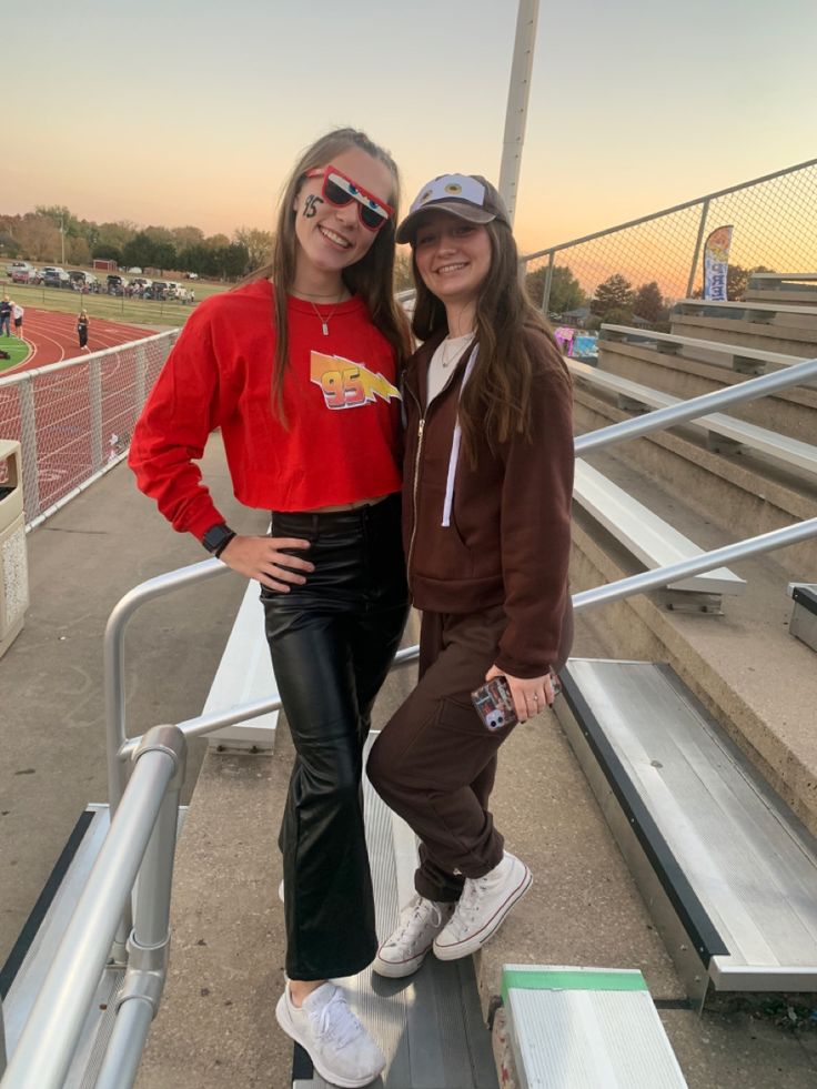 two girls standing on the bleachers with their arms around each other