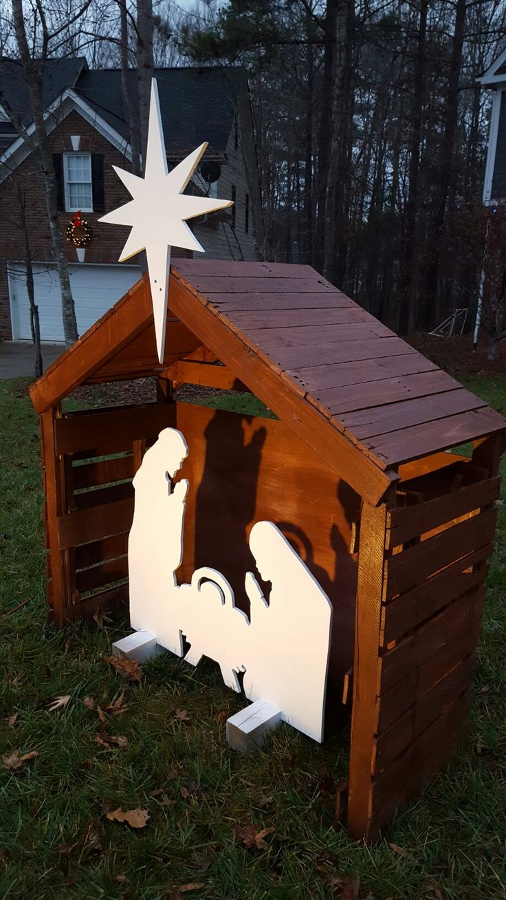 a wooden nativity scene with a star above the manger and baby jesus in it