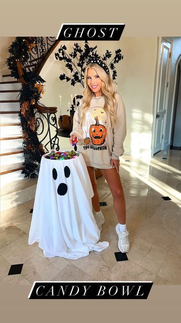 a woman standing in front of a table with a cake on it and the words ghost candy bowl