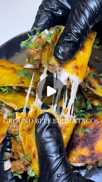 a person in black gloves is eating some food on a plate with cheese and other toppings