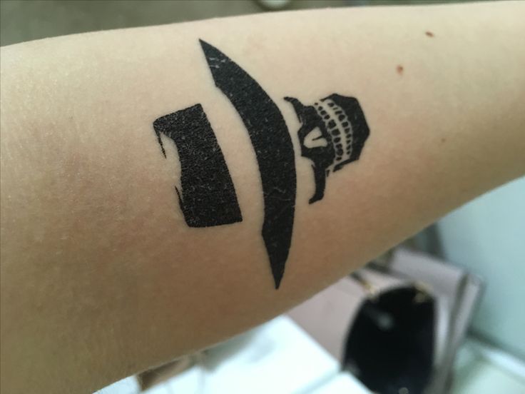 a person with a knife tattoo on their arm