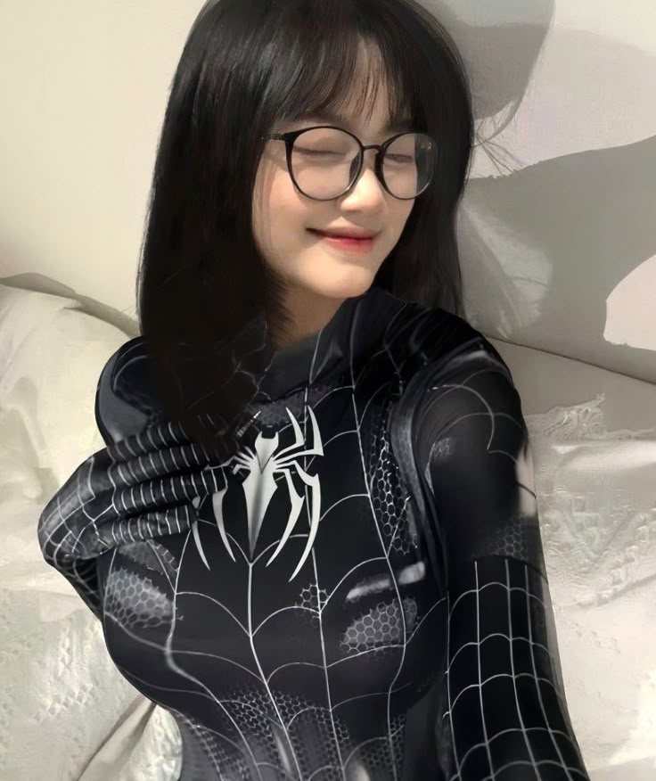 a woman wearing glasses and a spider suit