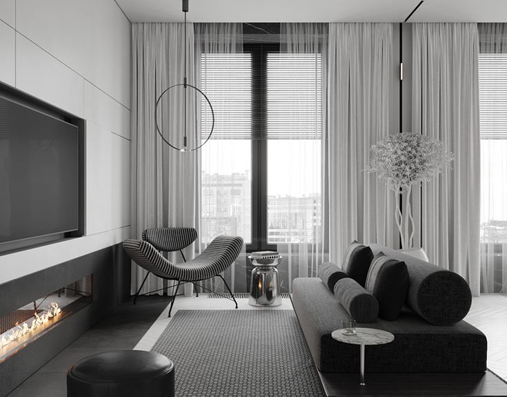 a black and white photo of a living room with a tv on the wall next to a fireplace