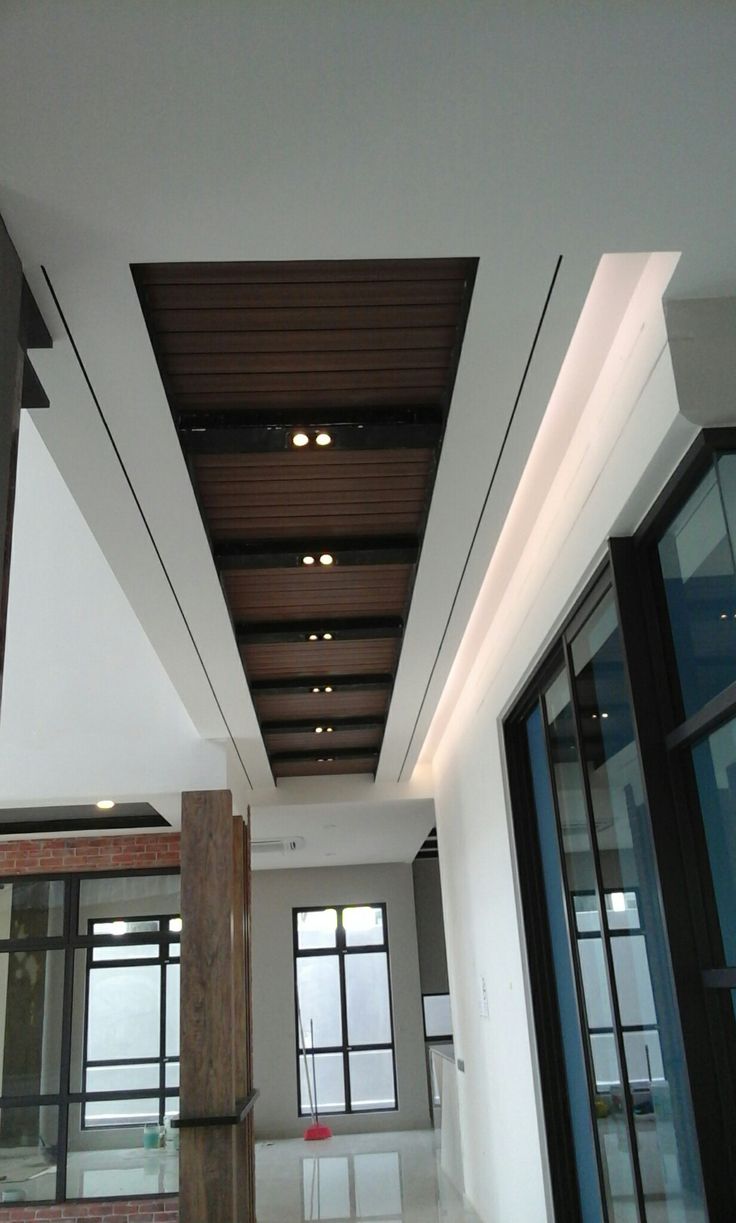 an empty room with wooden ceiling and glass doors