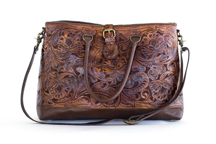 Genuine hand tooled floral leather on both sides with dark brown leather trim. This large bag comes with a detachable shoulder strap and smooth cowhide leather base and handles. Brass embellishments, zipper closure with magnetic flap closure make this bag a winner! Due to lighting used during photography, actual finishes may vary from imagery. This piece is not in stock and will be custom made for you! Production lead time is 8-10 weeks. Exterior: Zippered and magnetic closure Interior: 1 interi Tooled Leather Bag, Large Shoulder Bags, Dark Brown Leather, Large Bag, Leather Tooling, Hand Tools, Leather Trims, Cowhide Leather, Brown Leather