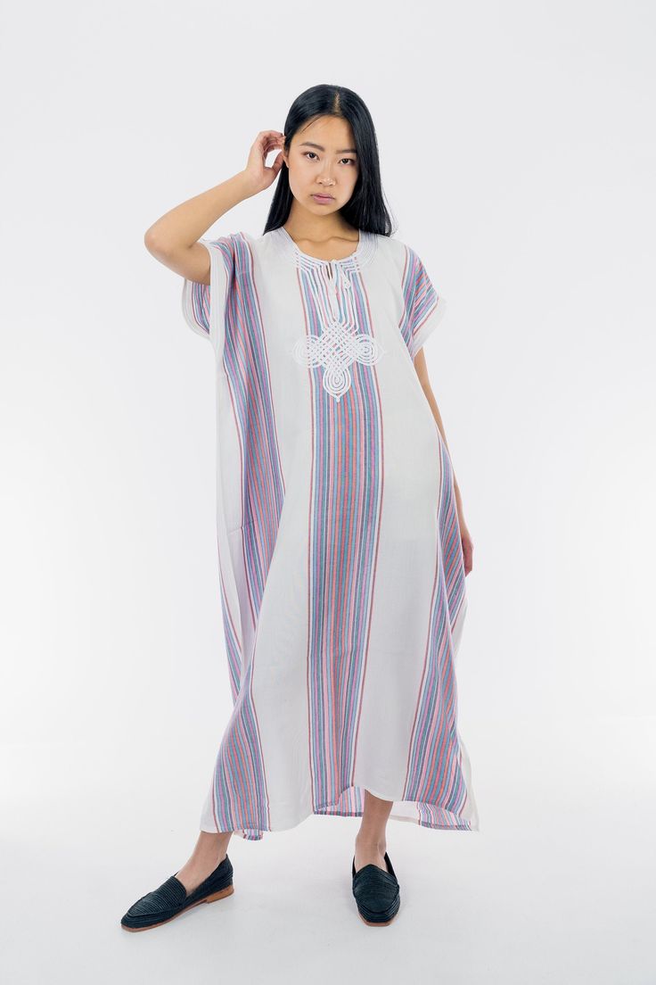 This cotton Kaftan has a particular stripy pattern and a rich white embroidery that makes it so unique in its style. To be worn from your grocery shopping trip, to chilled evenings at home, this kaftan is an essential for the summer! 100% cotton One size  Bust: 28 in Length: 50 in Model is 5'7 in (174 cm) Striped Kaftan For Spring Vacation, Casual White Short Sleeve Kaftan, Bohemian Striped Kaftan For Summer, Cotton Kaftan For Daywear In Spring, Spring Cotton Kaftan For Daywear, Casual Cotton Kaftan For Daywear, Traditional White Thobe For Summer, Traditional White Thobe For Beach, Short Sleeve Cotton Kaftan With Relaxed Fit