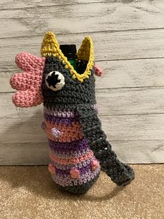 a crocheted bottle holder with a stuffed animal in the top and bottom part