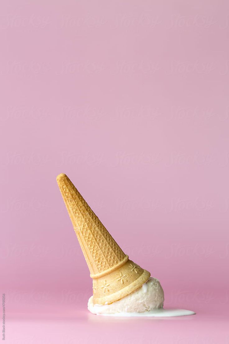 an ice cream cone sitting on top of a white plate against a pink background by luke bonn for stocksy