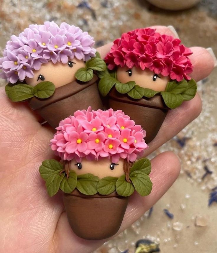 three little flowers are sitting on top of each other in the palm of someone's hand