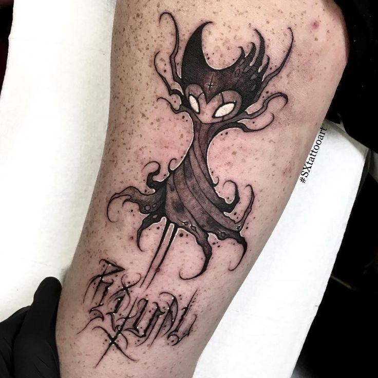 a black and white tattoo on the leg of a person