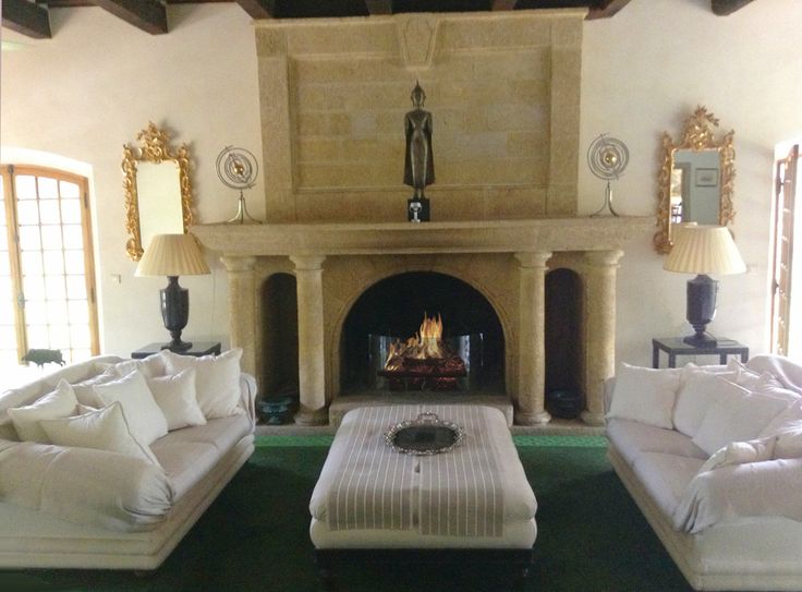 a living room with white couches and a fireplace