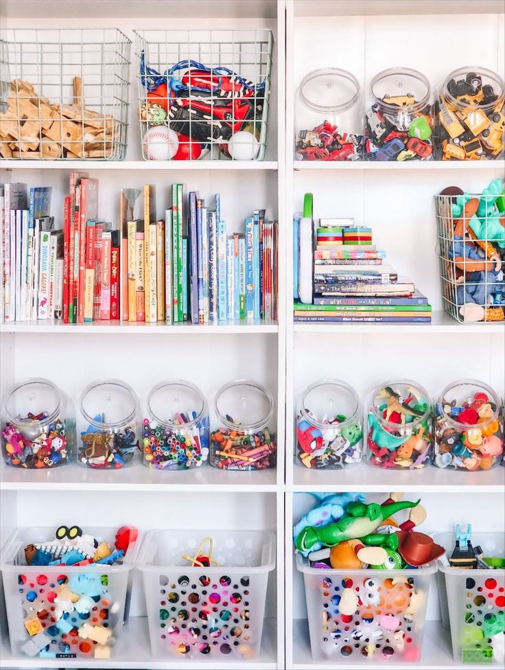 the shelves are filled with many different toys and books in bins on top of them