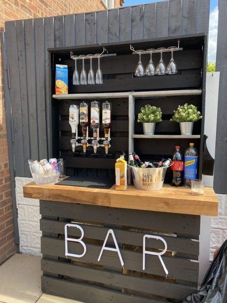 a bar made out of pallets with bottles and glasses on it