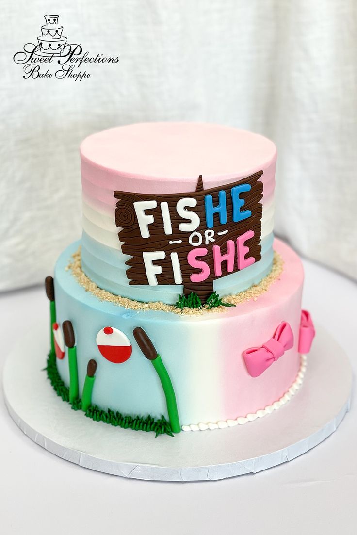 two tiered cake decorated with pink and blue frosting that says fish or fish