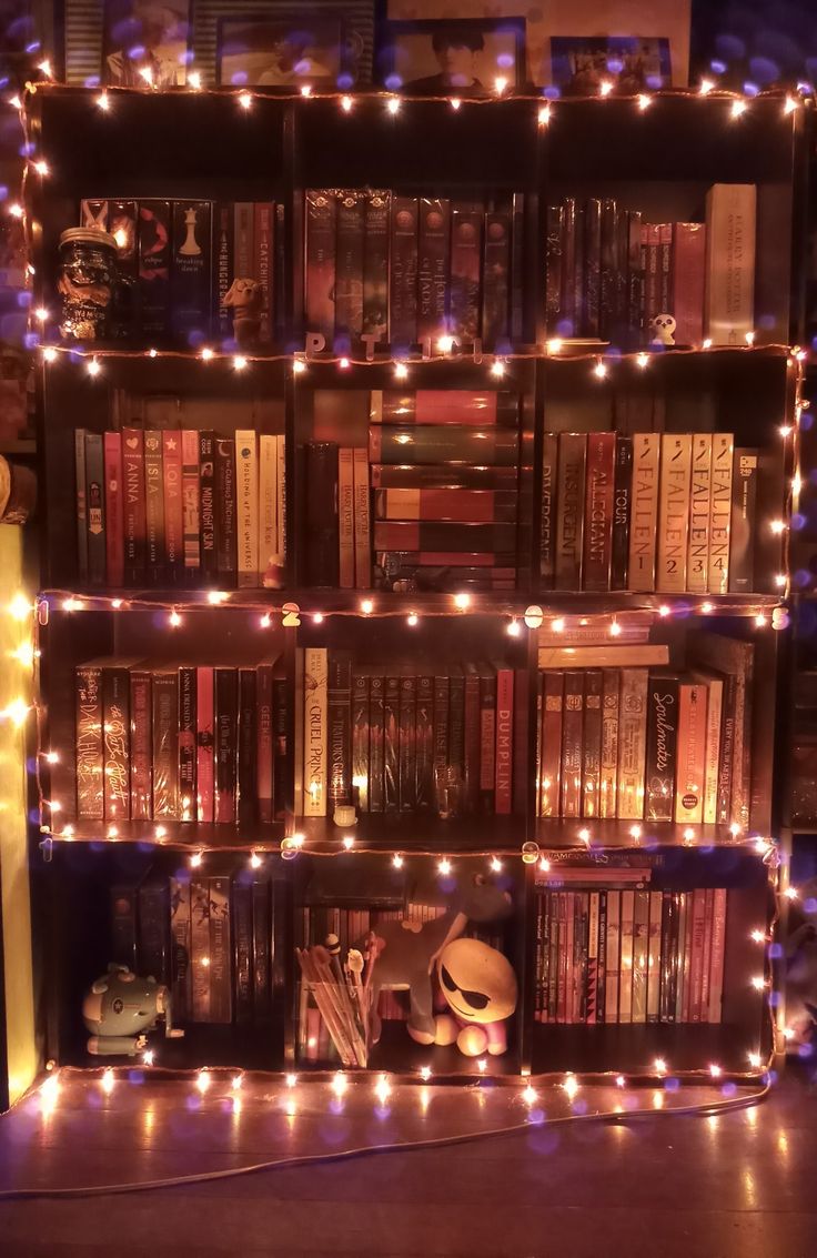 a book shelf filled with lots of books covered in lights