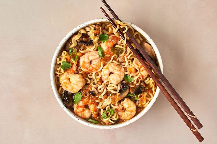 a bowl of shrimp noodle soup with chopsticks