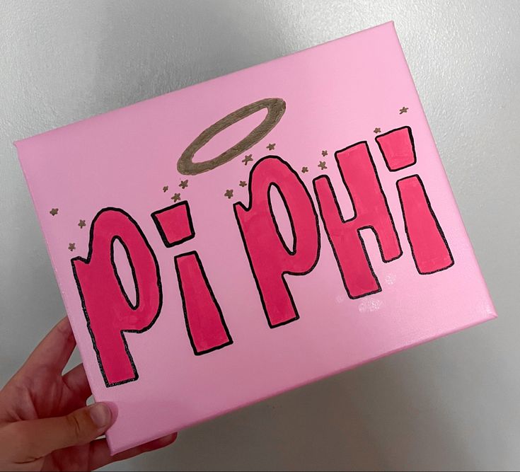 a hand holding up a pink box with the word pi phi on it and an angel above it