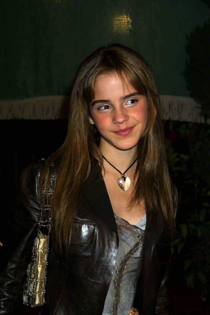 a young woman wearing a leather jacket and necklace