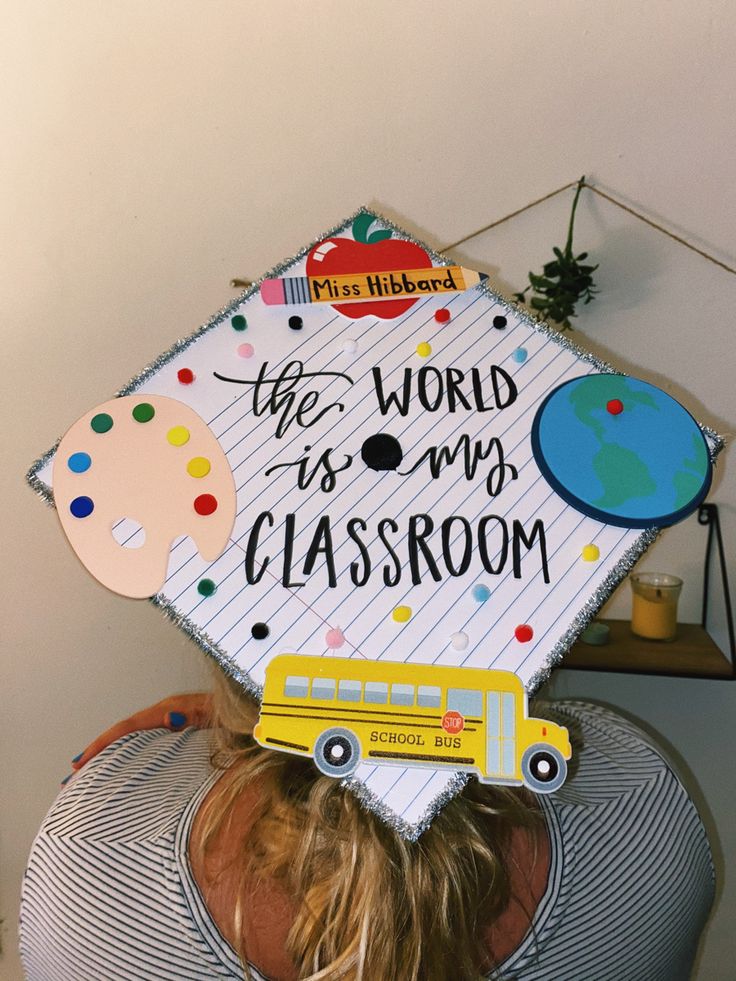 a woman wearing a graduation cap that says the world is my classroom