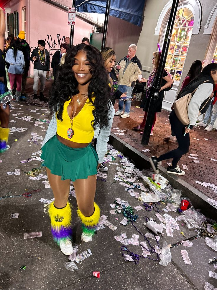 a woman in yellow and green outfit standing on the street with confetti all over her