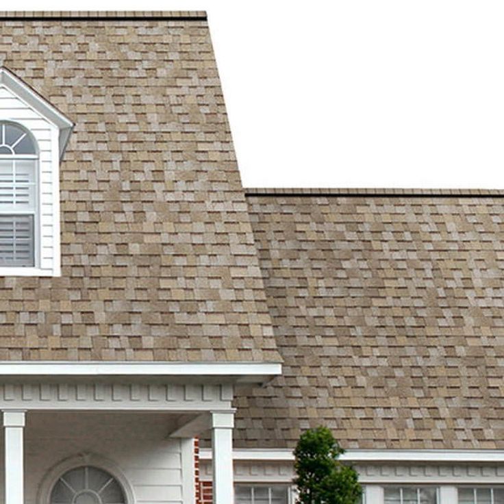 a clock on the side of a white house with brown shingles and brick roof