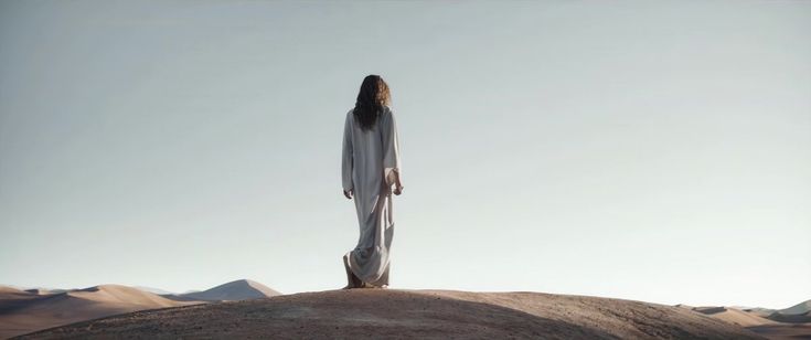 a woman standing on top of a hill