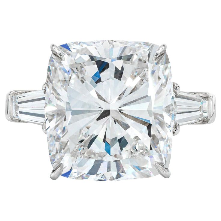 This exquisite ring showcases a dazzling 5.03 carat cushion-cut diamond, set in elegant 18K white gold. The diamond boasts an F color grade, reflecting an exceptional level of brightness and purity. With a clarity grade of VS1, it ensures minimal inclusions, enhancing its natural beauty. The tapered baguette side diamonds add a sophisticated touch, framing the centerpiece with grace. Featuring very good polish and symmetry, the diamond exhibits a harmonious and refined appearance. The absence of Classic Diamond Ring, Cushion Cut Diamond Engagement Ring, Cushion Diamond Ring, Brilliant Cut Diamond Ring, Cushion Cut Diamond Ring, Contemporary Engagement Rings, Three Stone Diamond Ring, Baguette Diamond Rings, Cushion Cut Diamond