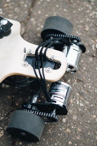 an electric skateboard laying on the ground with its wheels still attached to it's body