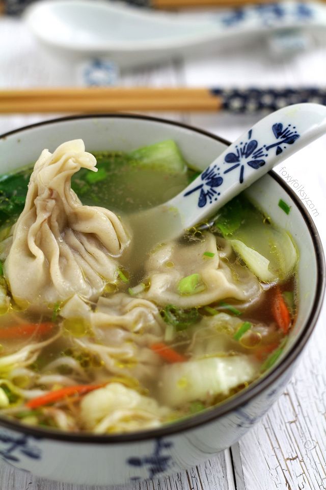 a bowl of soup with dumplings and vegetables