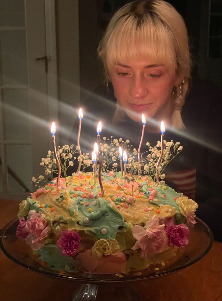 a woman blowing out candles on a cake