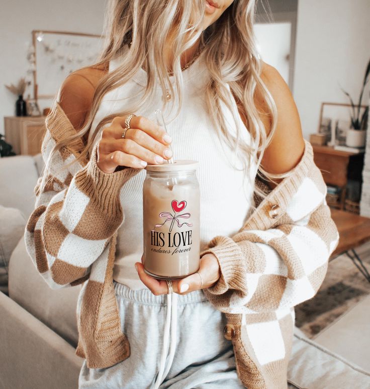 a woman holding a jar of coffee in her hands