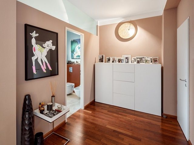 a living room filled with furniture and pictures on the wall next to a wooden floor