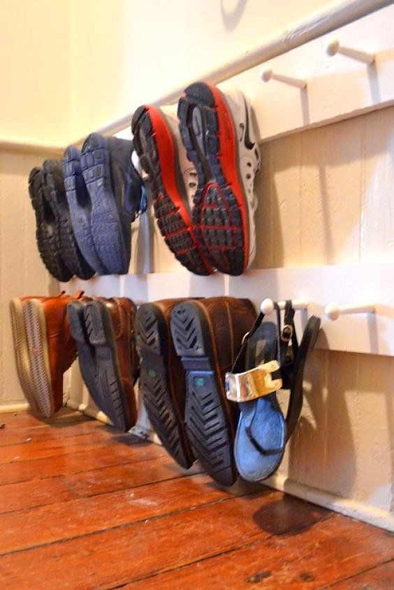 several pairs of shoes are hanging on the wall