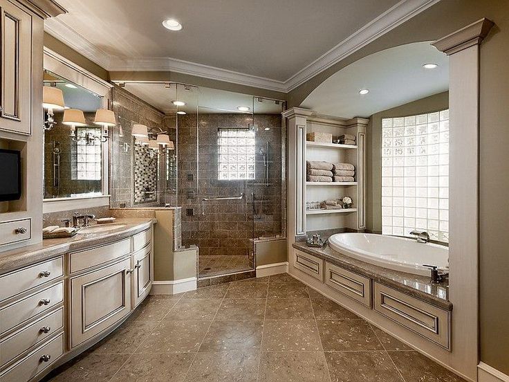 a large bathroom with a walk in shower next to a bathtub and double sinks