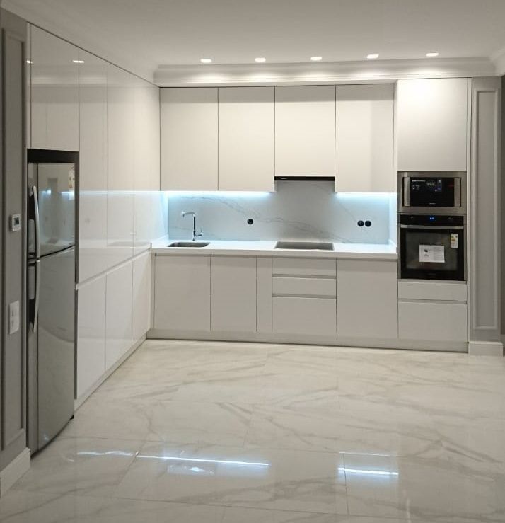 an empty kitchen with marble floors and white cabinets