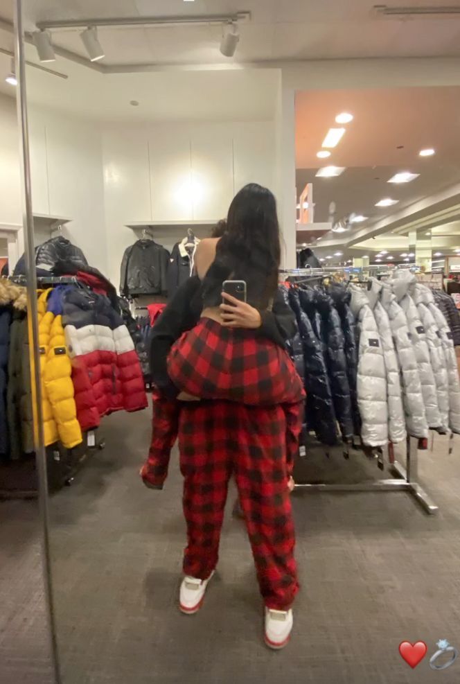 a woman taking a selfie in a clothing store