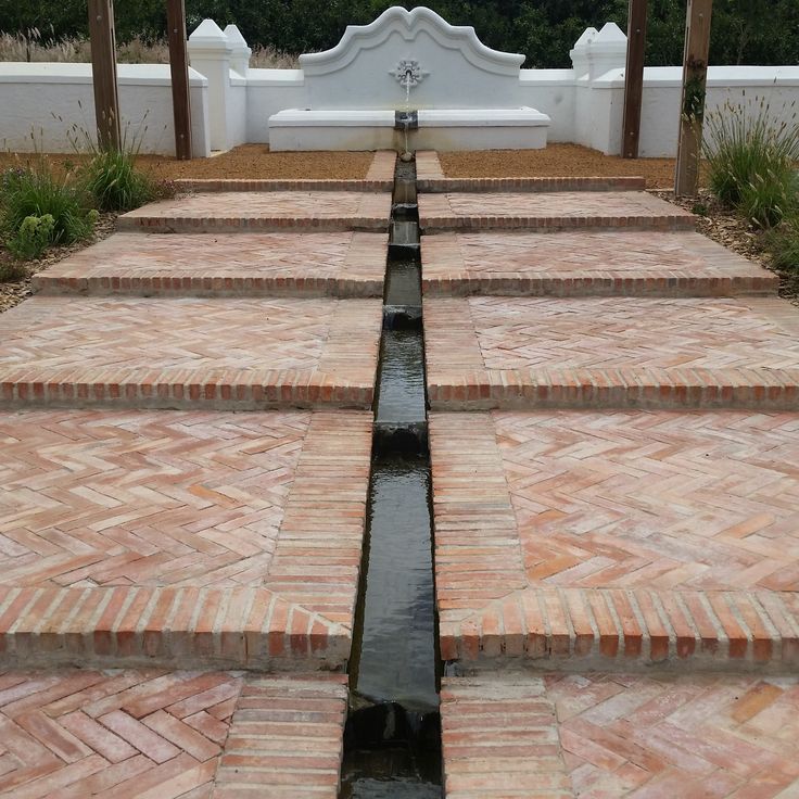 the water is running down the side of the steps in front of the bench area