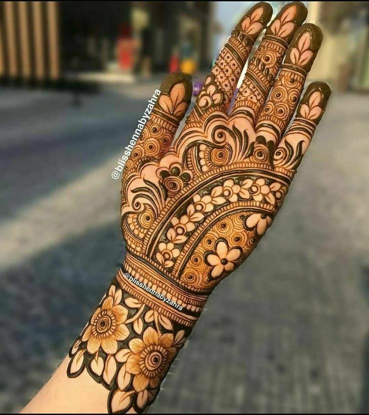 a woman's hand with henna tattoos on it