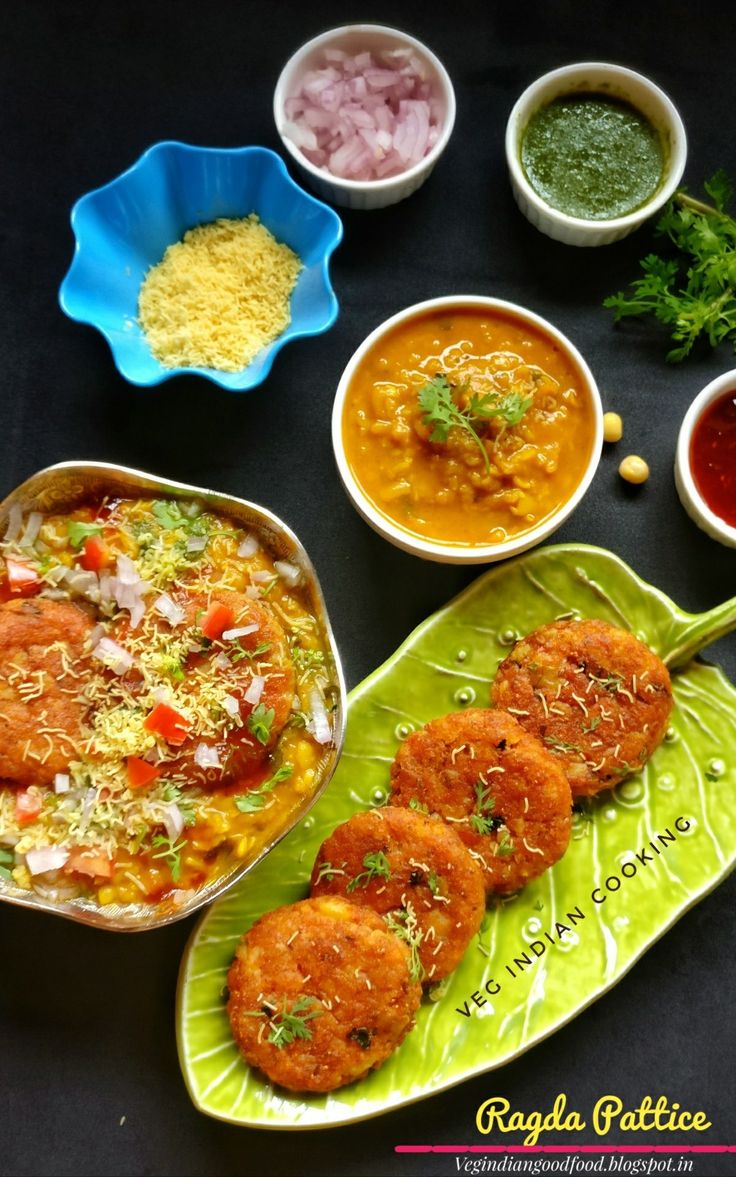 some food is sitting on a green leaf next to bowls and spoons with sauces