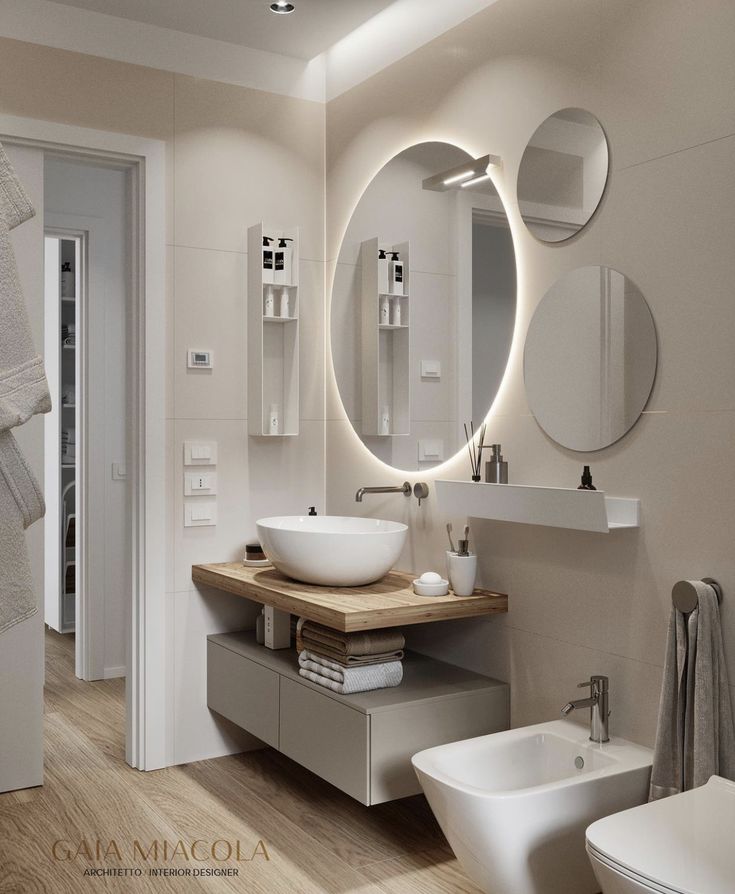 a modern bathroom with round mirrors above the sink and wooden countertop, along with two sinks