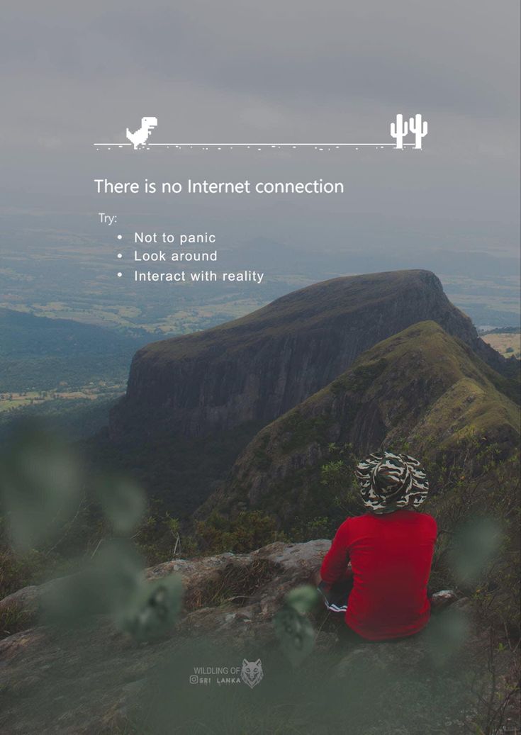 a person sitting on top of a mountain next to a red chair with the words there is no internet connection