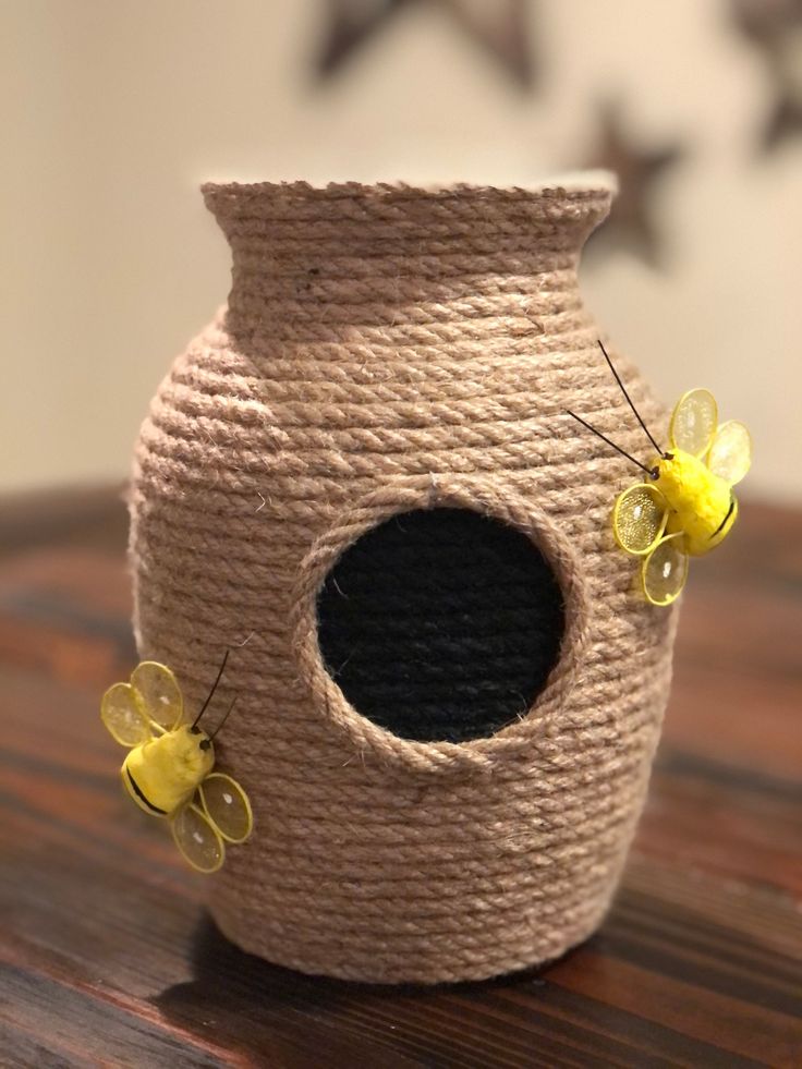 a vase that has some yellow flowers on the inside and outside of it, sitting on a wooden table