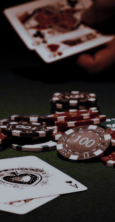 playing cards and chips on a table with one person holding the card in their hand