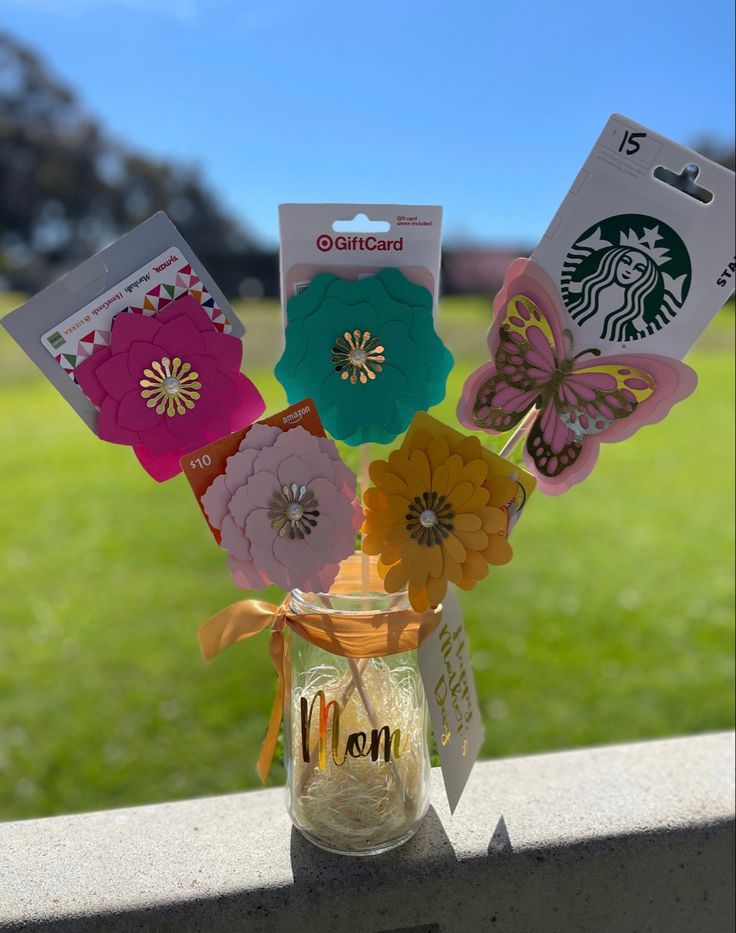 a mason jar filled with paper flowers on top of a table