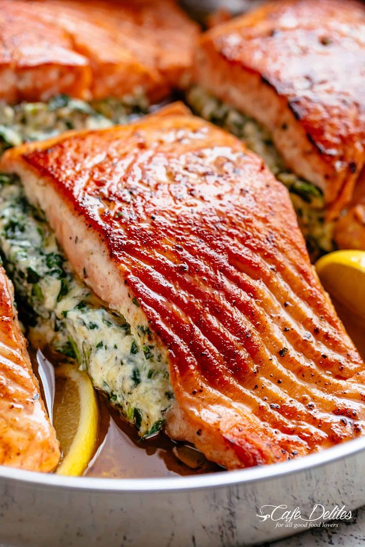 salmon with spinach and lemons in a pan